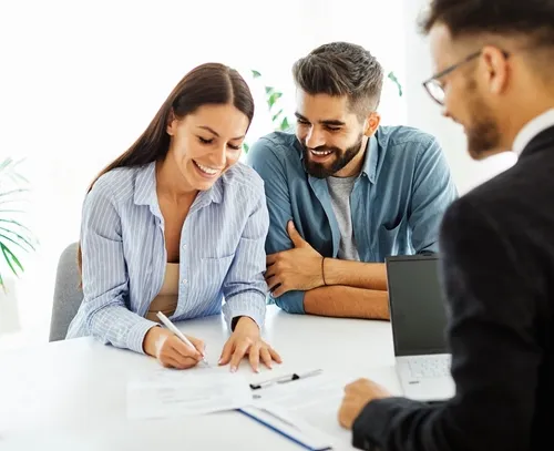 Couple signing documents with their solicitor