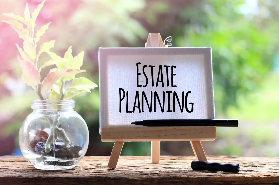 Small easel with estate planning written on it beside a plant