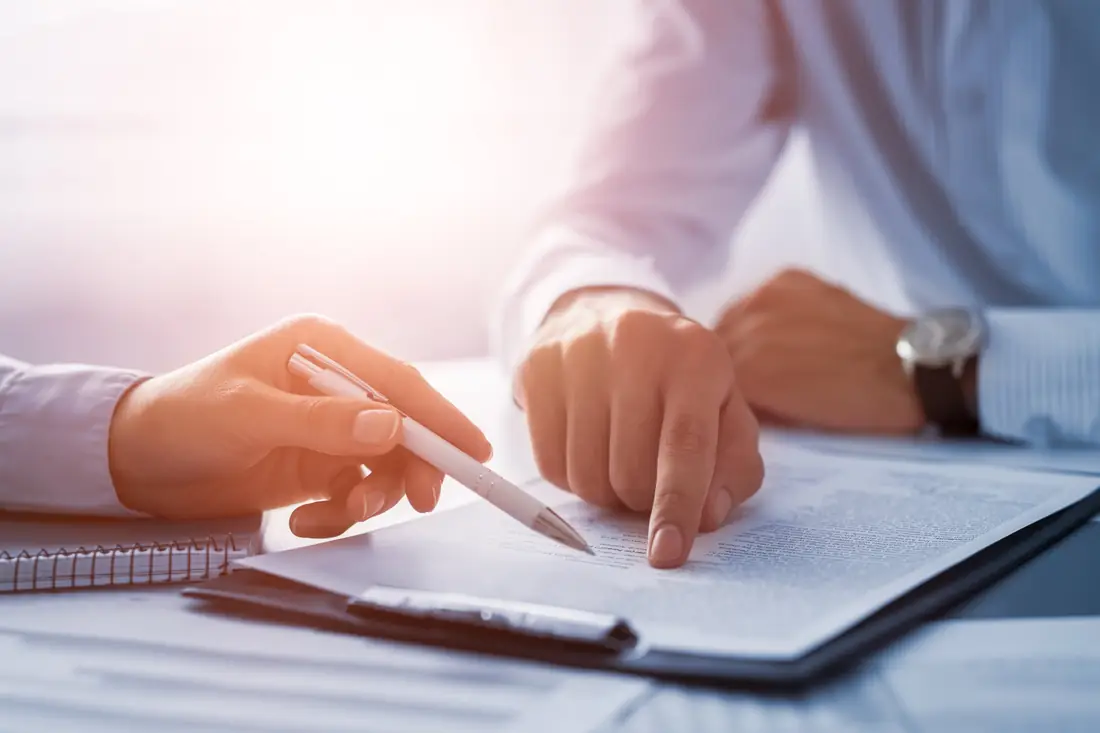 Two people reviewing a document with a pen